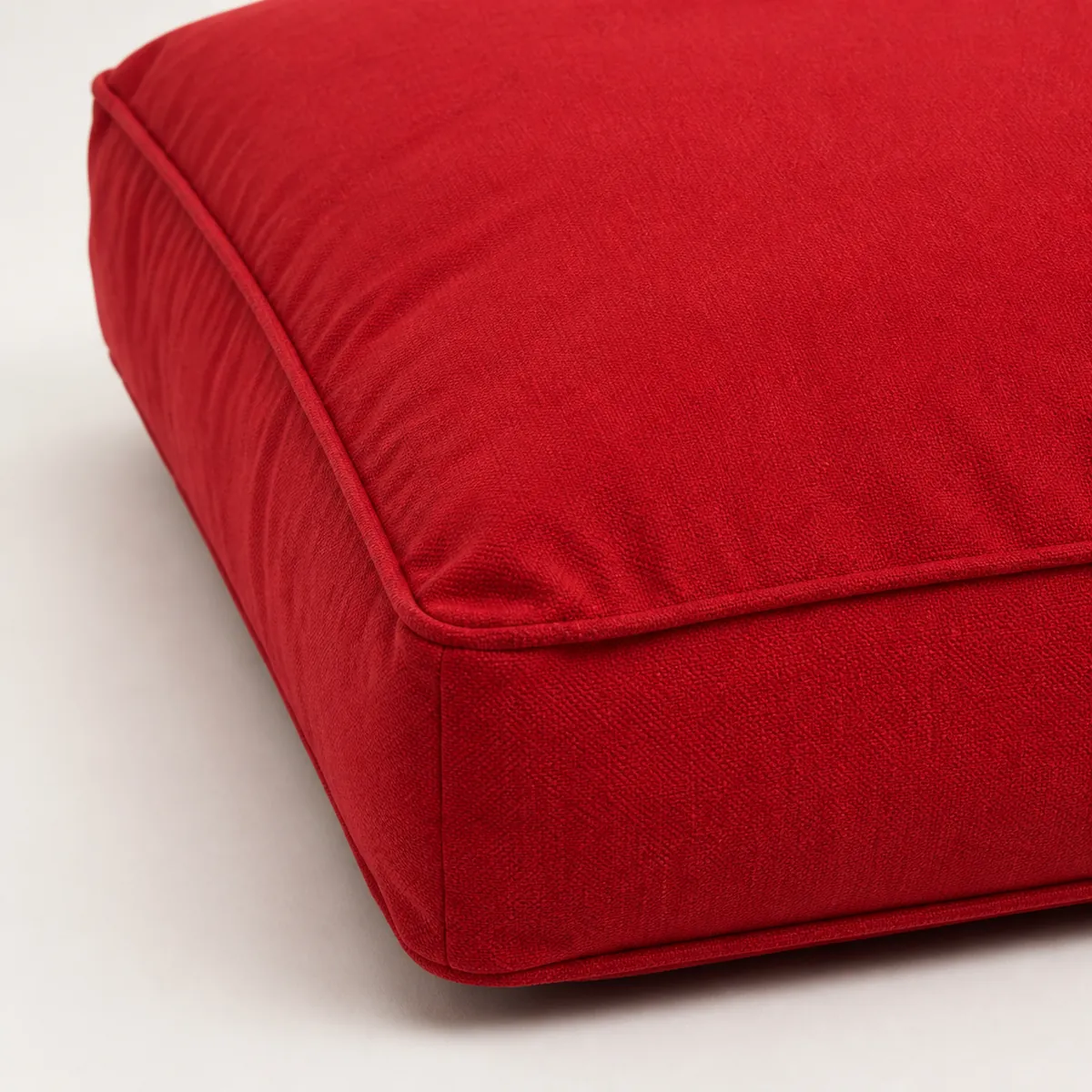 Close-up of red dog bed fabric, piping, and filled edge